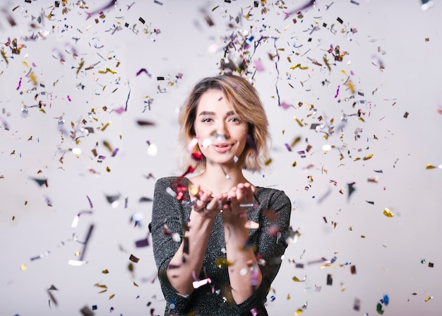 Photo smiling woman with flying confetti at party