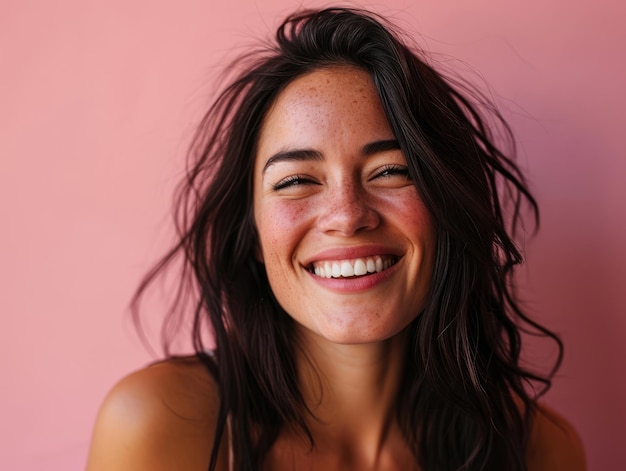 Smiling woman with freckles on pink background