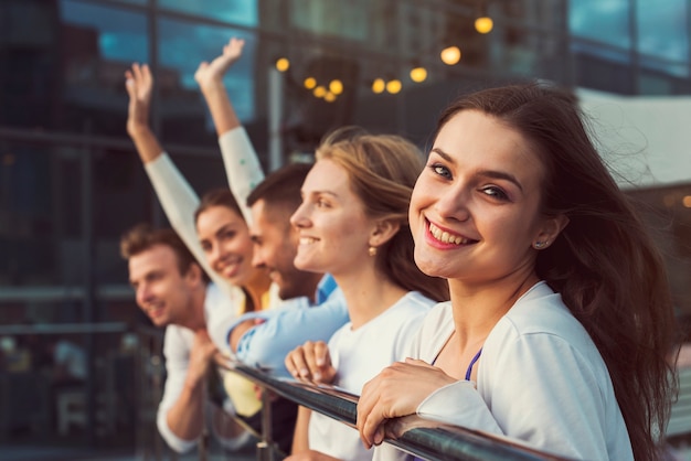 Foto donna sorridente con gli amici nella priorità bassa