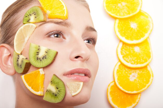 Photo smiling woman with fruit mask on her face isolated