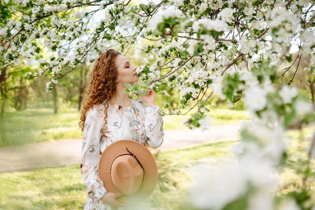 Smiling woman with hat in spring park The concept of relax travel freedom