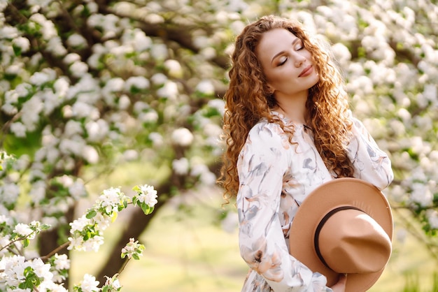 Smiling woman with hat in spring park The concept of relax travel freedom