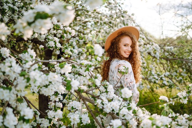 Smiling woman with hat in spring park The concept of relax travel freedom