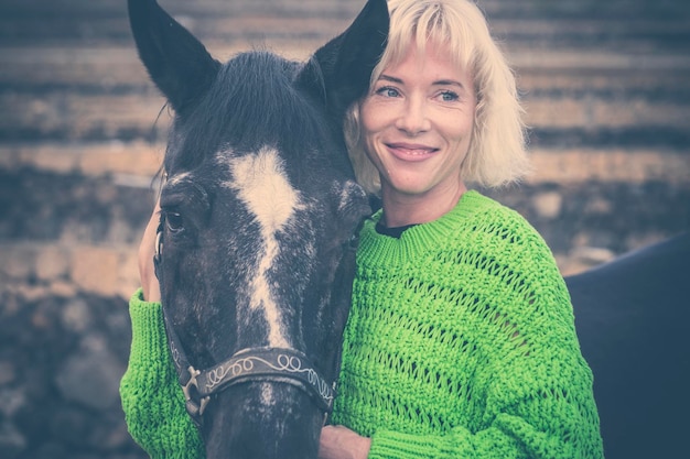 Smiling woman with horse outdoors
