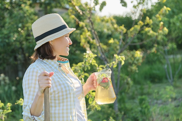 さわやかな自家製ドリンクの水差しと笑顔の女性