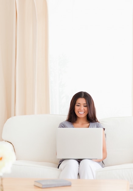 smiling woman with notebook on the sofa