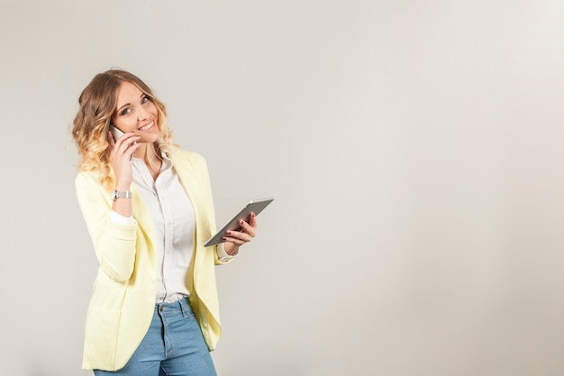 Smiling woman with smartphone and tablet