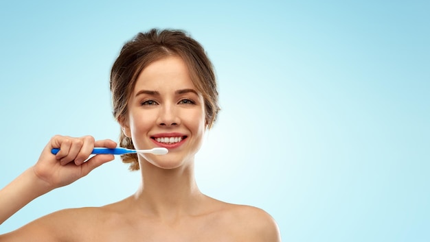 歯ブラシを持った笑顔の女性が歯を掃除している