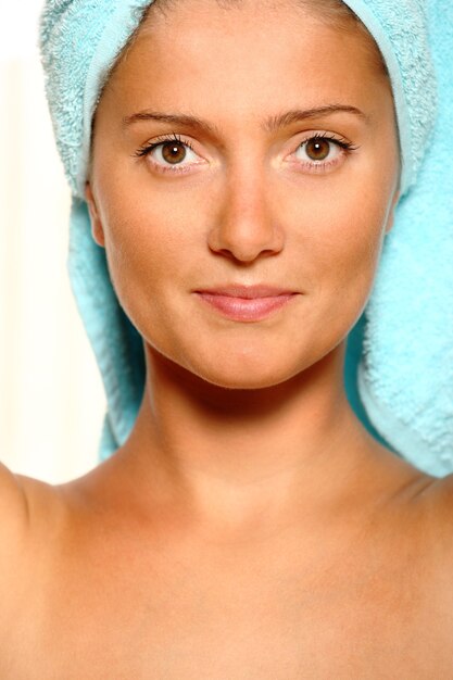 a smiling woman with a towel on her head