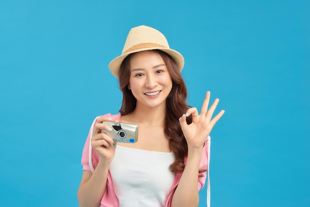 Smiling woman with travel case holding photo camera traveler girl isolated portrait