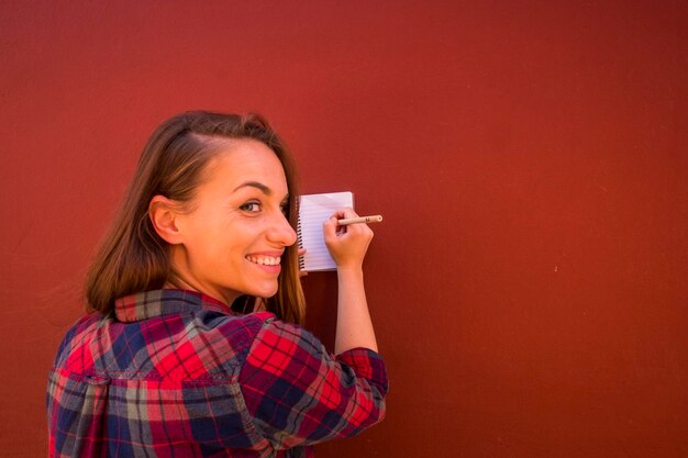 Smiling woman writing on note pad