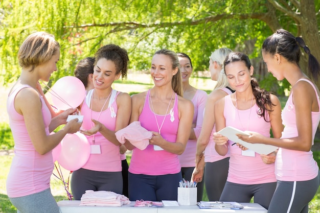 Donne sorridenti che organizzano l'evento per consapevolezza del cancro al seno