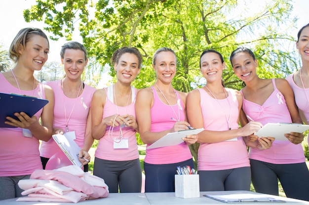 Smiling women organising event for breast cancer awareness