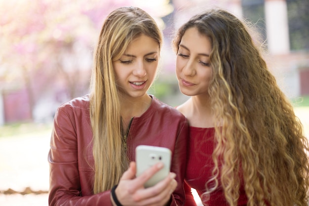 Smiling women using a cell phone