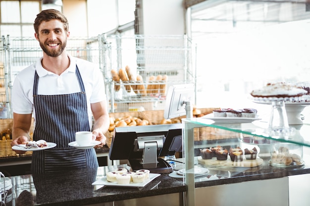 Smiling worker prepares breakfast