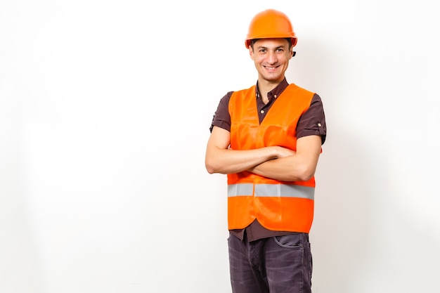 smiling worker in protective uniform and protective helmet isolated on white