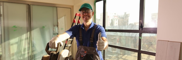 Smiling worker standing near circular saw and show thumb up repair house and home improvement