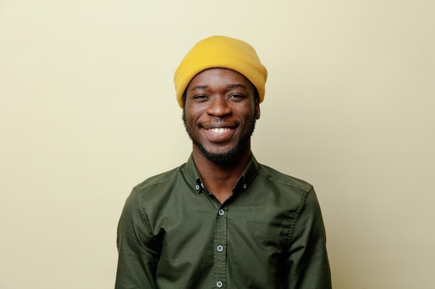 Smiling young african american male in hat wearing green shirt isoloated on white background