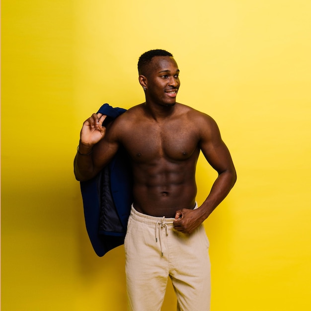 Улыбающийся молодой афроамериканец парень изолирован на желтом фоне студии люди искренние эмоции