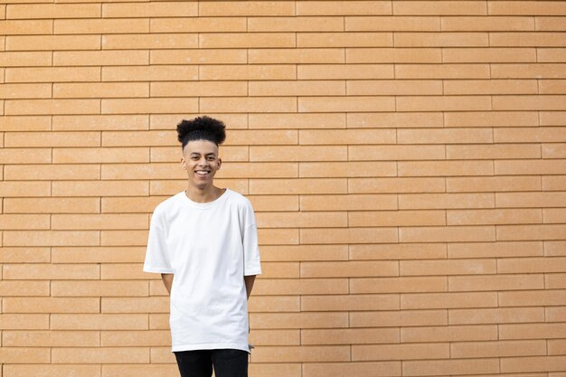 Smiling young African American man with a ponytail wearing a white Tshirt