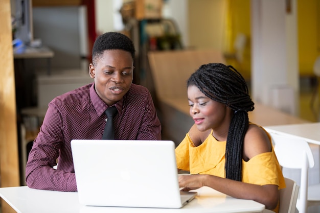 Smiling young african american professional businessman and businesswoman together working in office