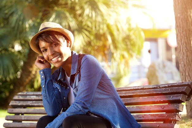 Giovane donna afroamericana sorridente che si siede fuori