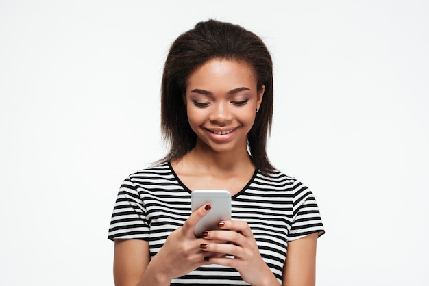 Smiling young african lady chatting by phone.