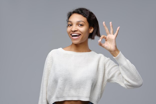 Улыбающаяся молодая афроамериканка показывает все прекрасные жесты