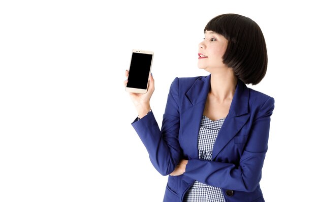 Smiling young Asian businesswoman in elegant outfit showing modern mobile phone with empty black screen against white background