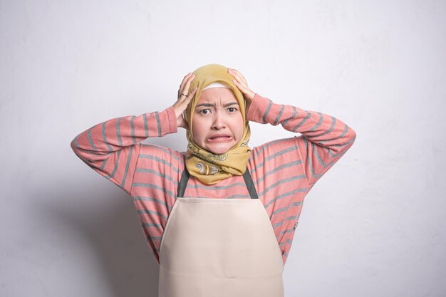 Smiling young Asian muslim woman wearing hijab and apron housewife muslim lifestyle concept