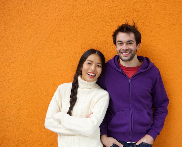 Smiling young asian woman standing next to happy young man 