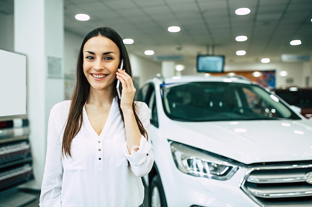 Smiling young beautiful woman in dealership Beautiful woman buying a new car for job and travel in dealership girl customerx9