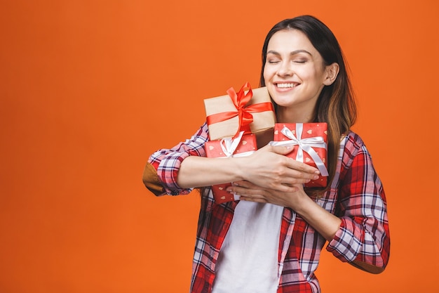 Smiling young beautiful woman holds red gift boxes