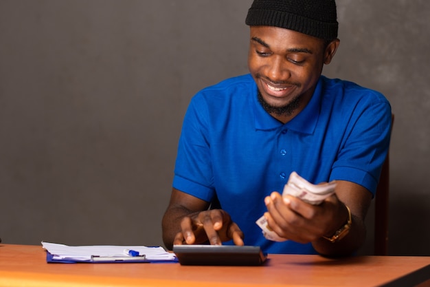 いくつかの財務計算をしている若い黒人男性の笑顔
