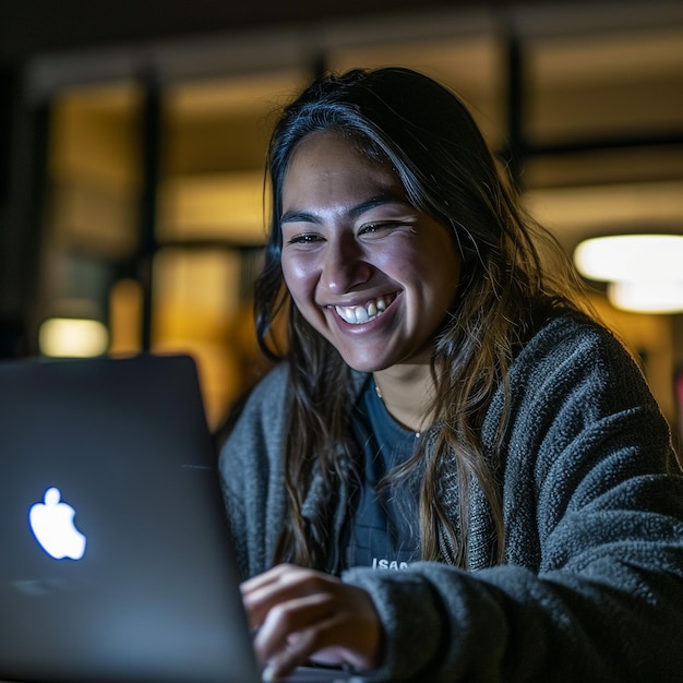 Smiling young black woman in wireless headphones sitting at desk table working on laptop and writing letter in paper notebook taking notes watching weninar holding pen in hand free copy space