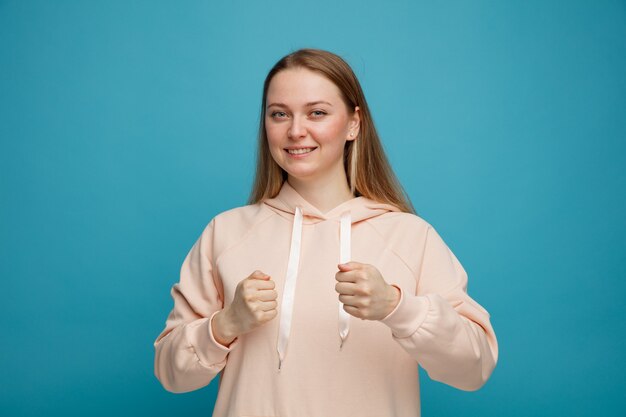 Smiling young blonde woman doing boxing gesture 