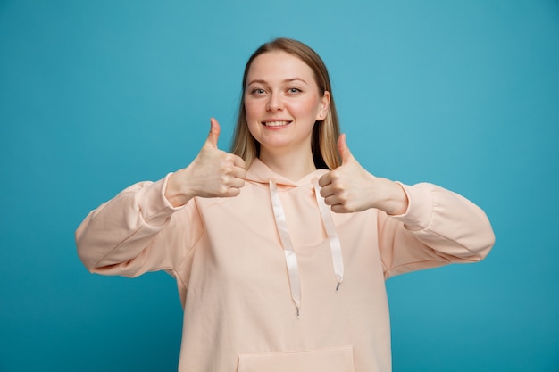 Smiling young blonde woman showing thumbs up 