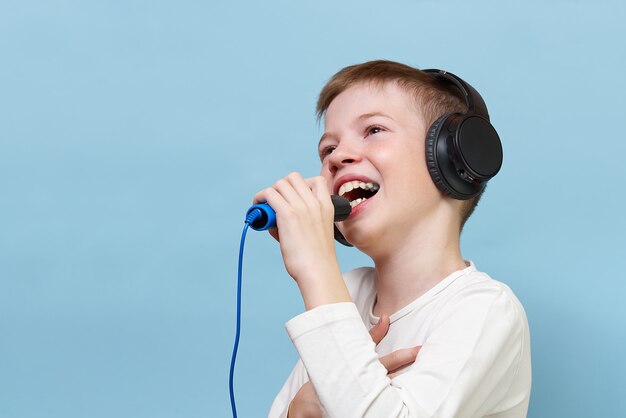 Smiling young boy in headphones singing