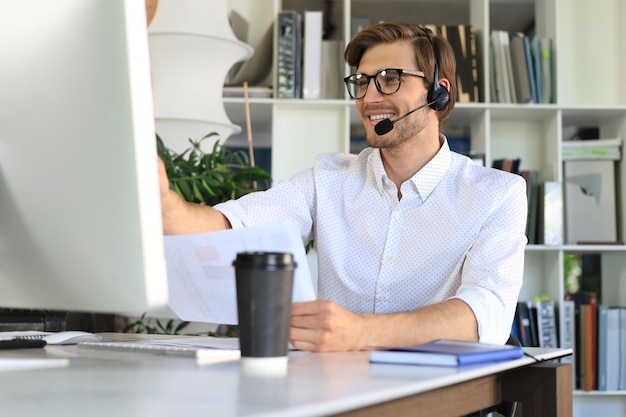 Smiling young business man having video call in office.