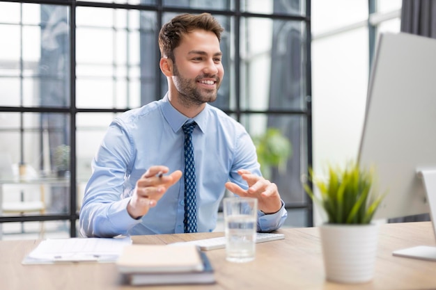 Smiling young business man having video call in office