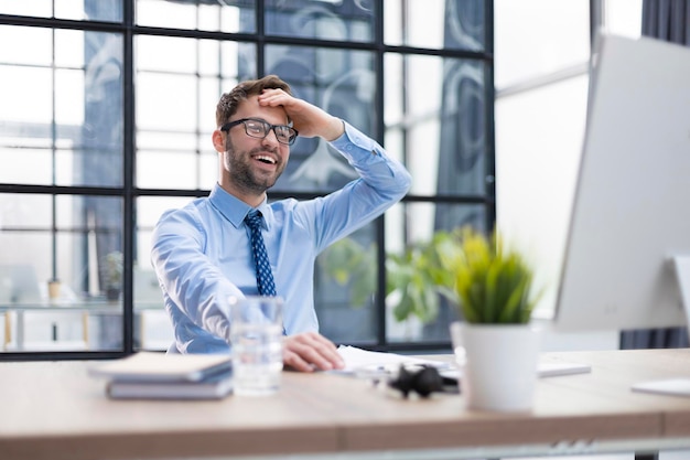 Smiling young business man having video call in office