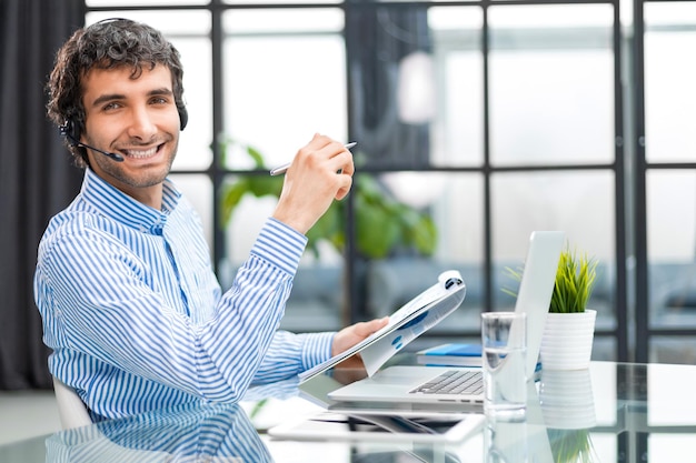 Smiling young business man having video call in office