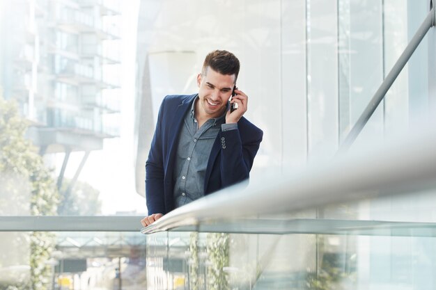 Smiling young business man listening with cellphone 