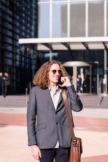 Smiling young business man talking by mobile phone