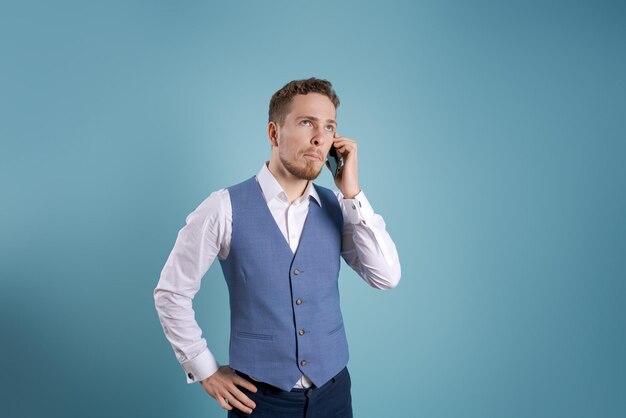 Smiling young business man using smartphone to contact family and friends or