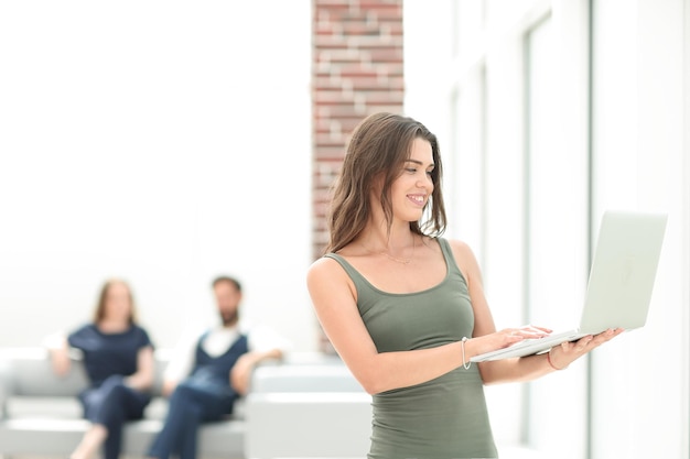 Smiling young business woman looking at laptop screen