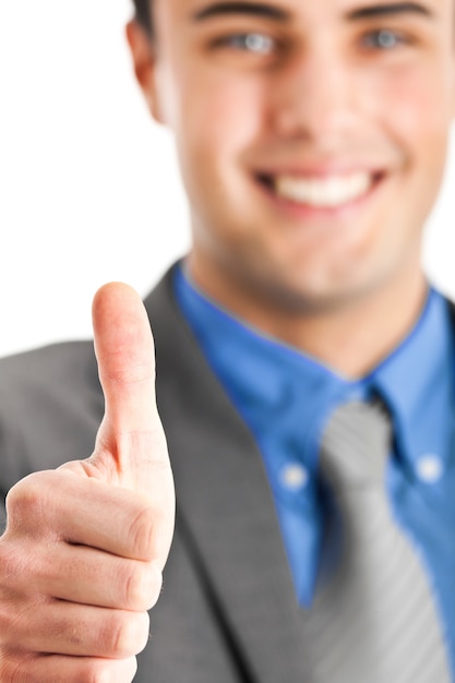 Smiling young businessman showing thumbs up