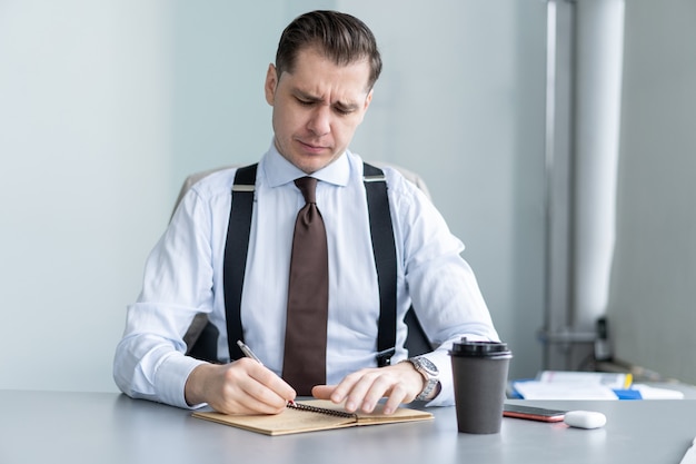 Photo smiling young businessman sit at desk talk on webcam having video call or conversation with client, motivated male coach or trainer speak shoot online tutorial, record training course