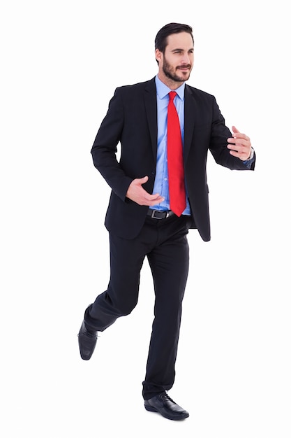 Smiling young businessman in suit running 