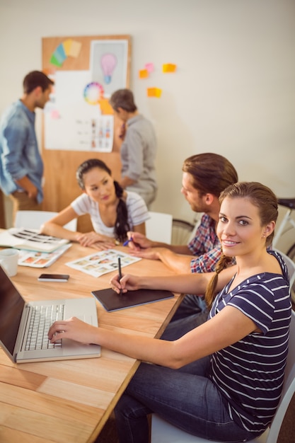 Smiling young businesswoman using laptop